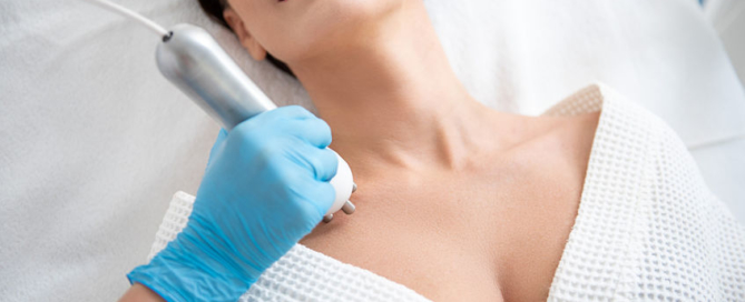 Woman in medispa receiving treatment to decolletage